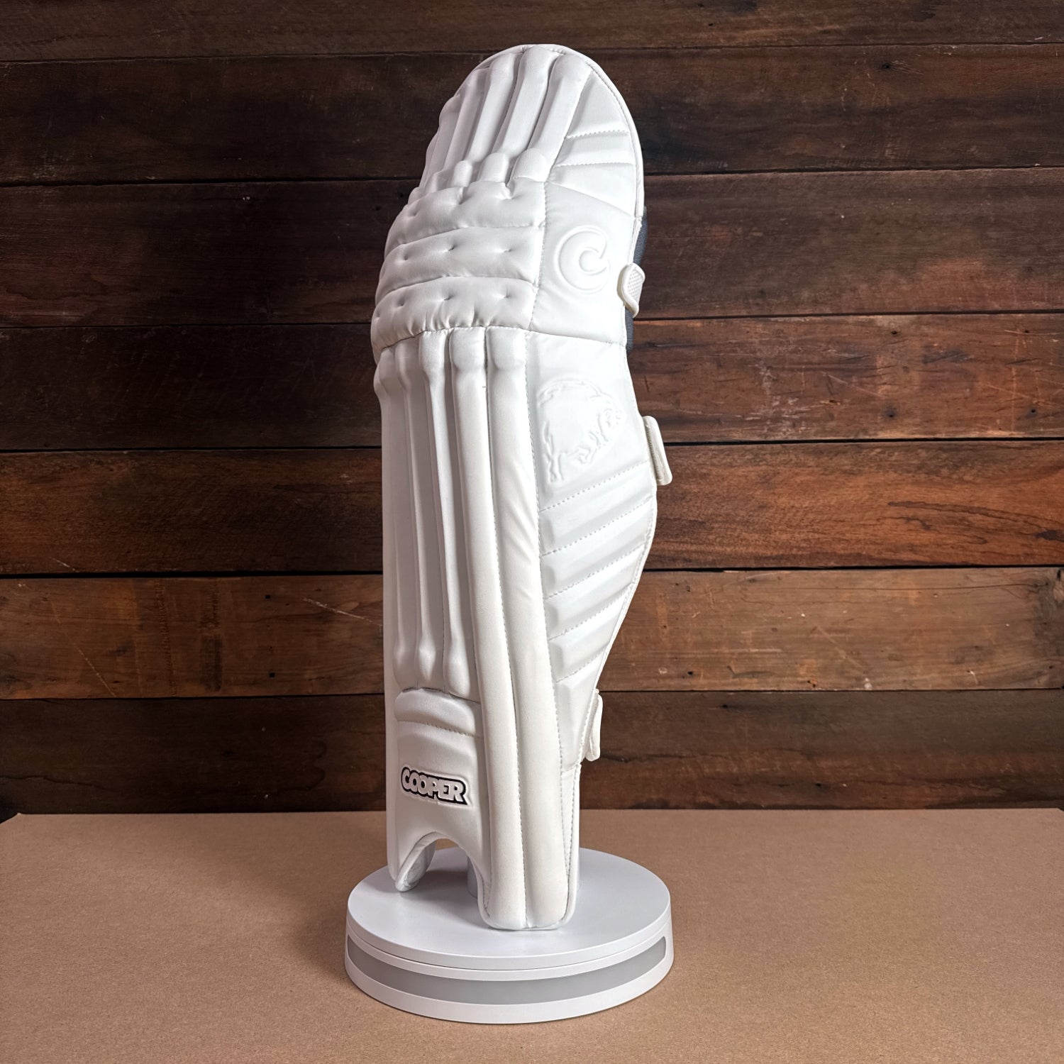 Premium white cricket batting gloves displayed on a stand, showcasing their modern design and quality craftsmanship.