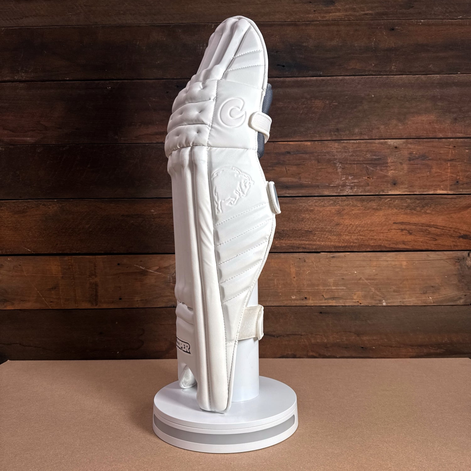 Bison Youth Cricket Pads displayed on a stand, featuring premium foam construction for enhanced protection and comfort.