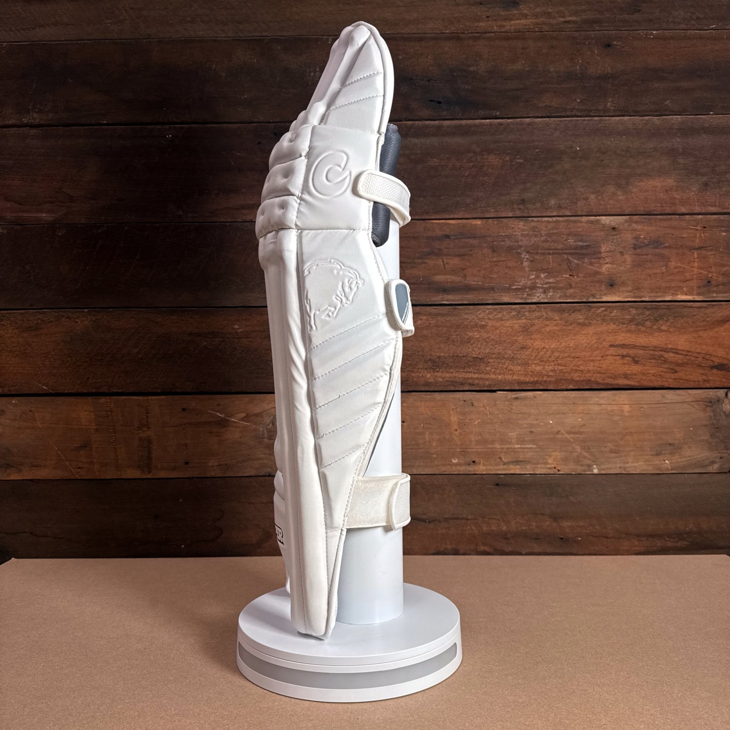 Bison cricket pads 2024-25 youth model displayed on a stand, featuring premium foam and sleek design for protection and comfort.