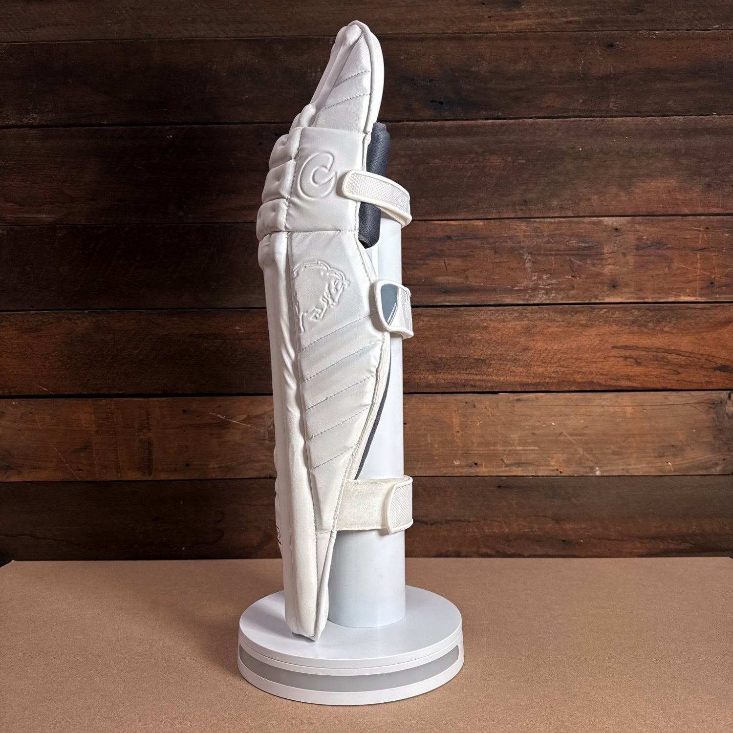 Bison Cricket Pads 2024-25 for youth, showcasing premium foam design and secure fit on display stand.