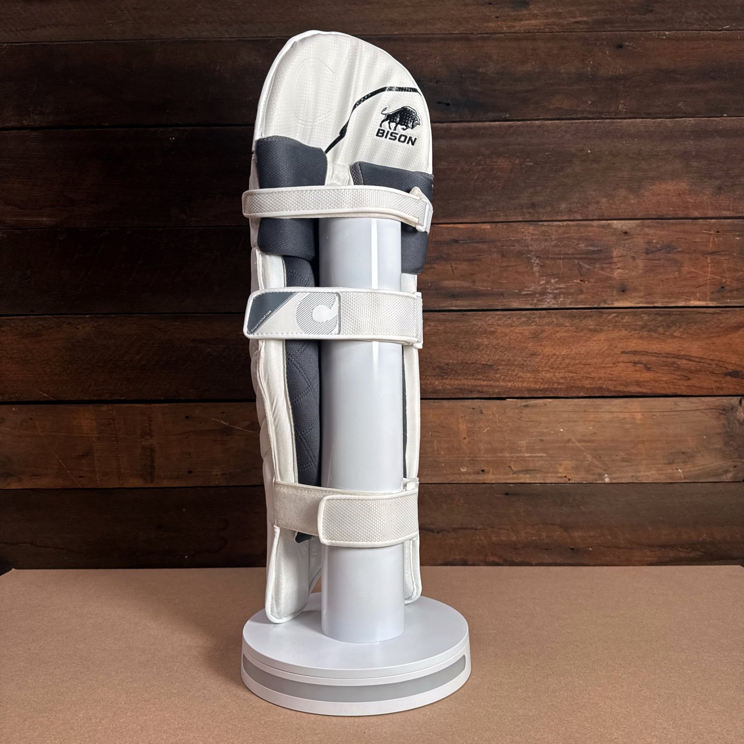 Bison youth cricket pads displayed on a stand, showcasing premium foam and sleek design for protection and comfort.