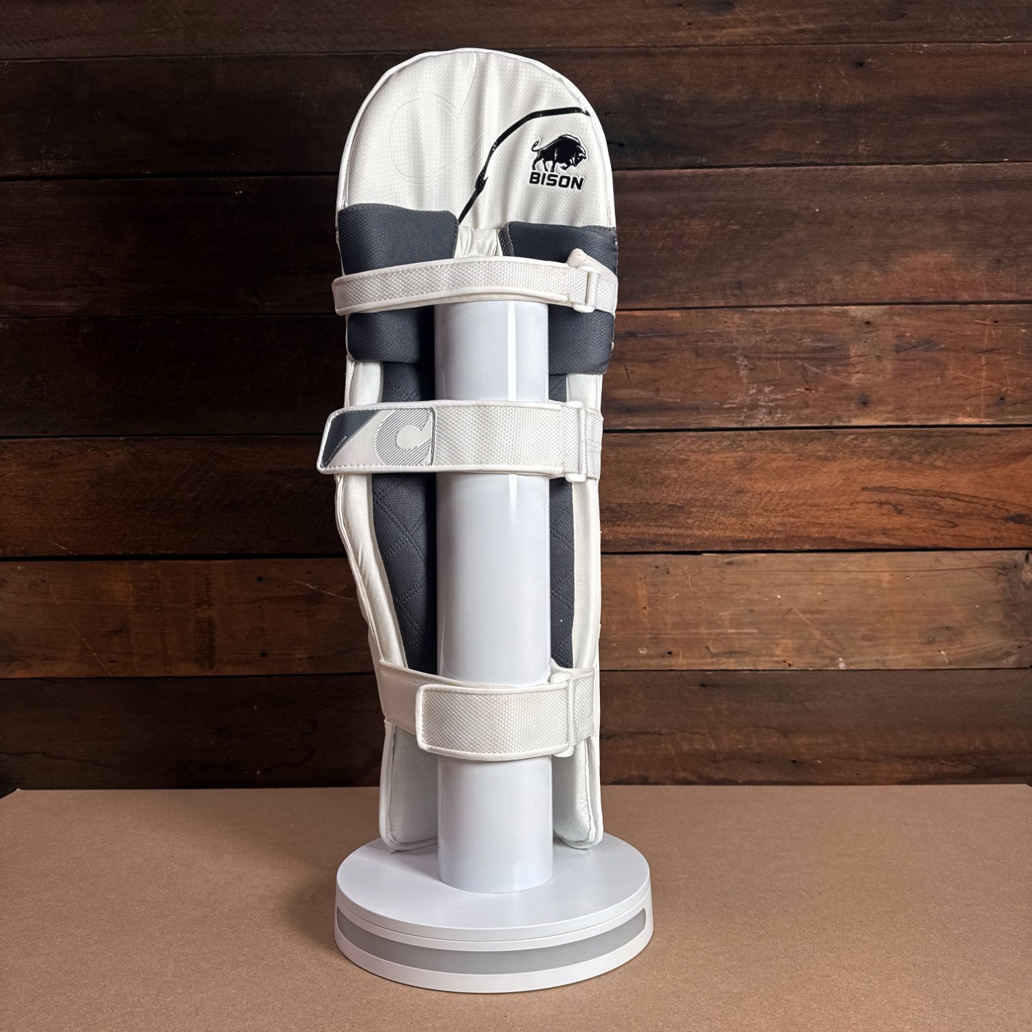 Bison cricket pads displayed on a stand, showcasing premium design and protection for youth players.