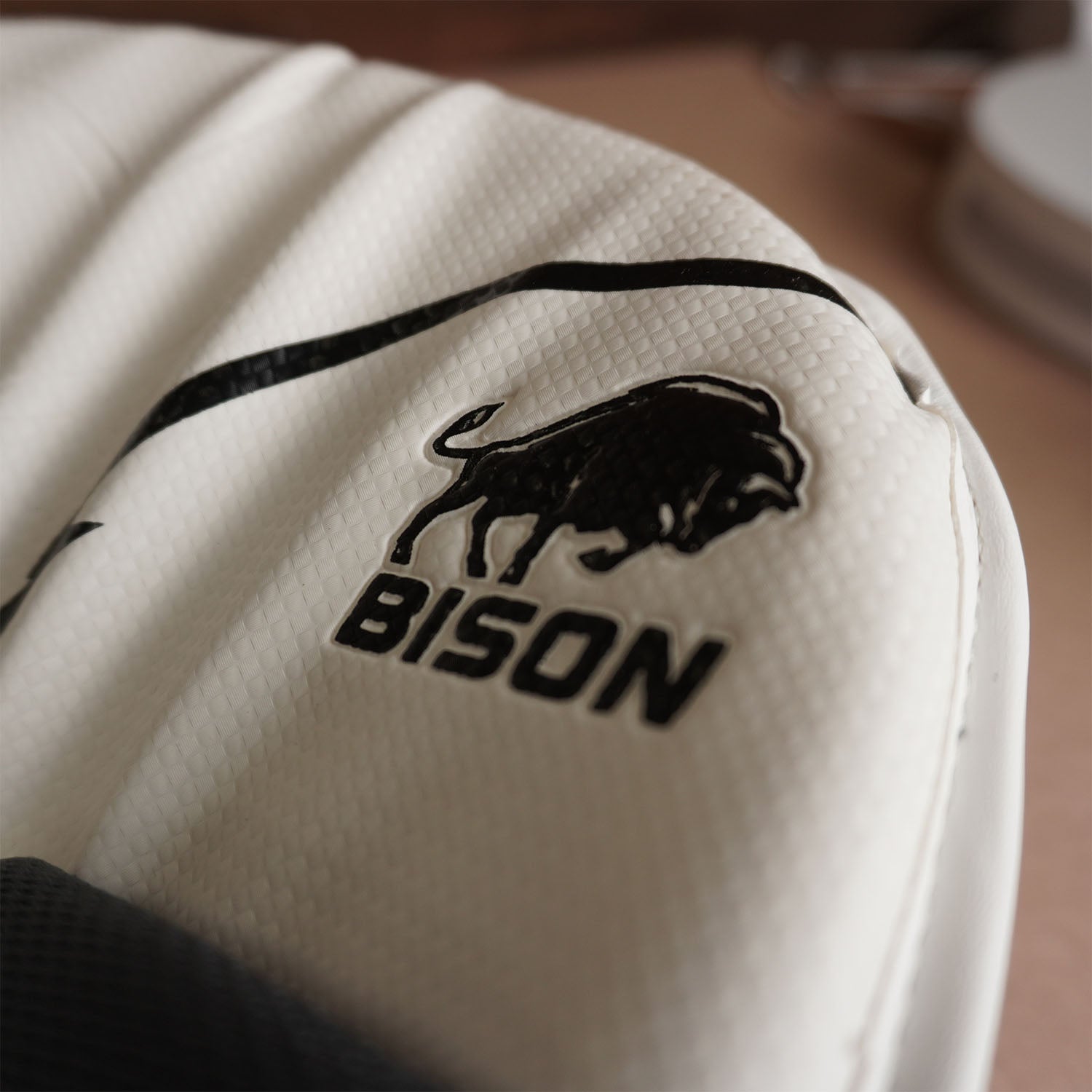 Close-up of Bison Cricket Pads showing premium foam and logo, highlighting protection and performance for youth players.