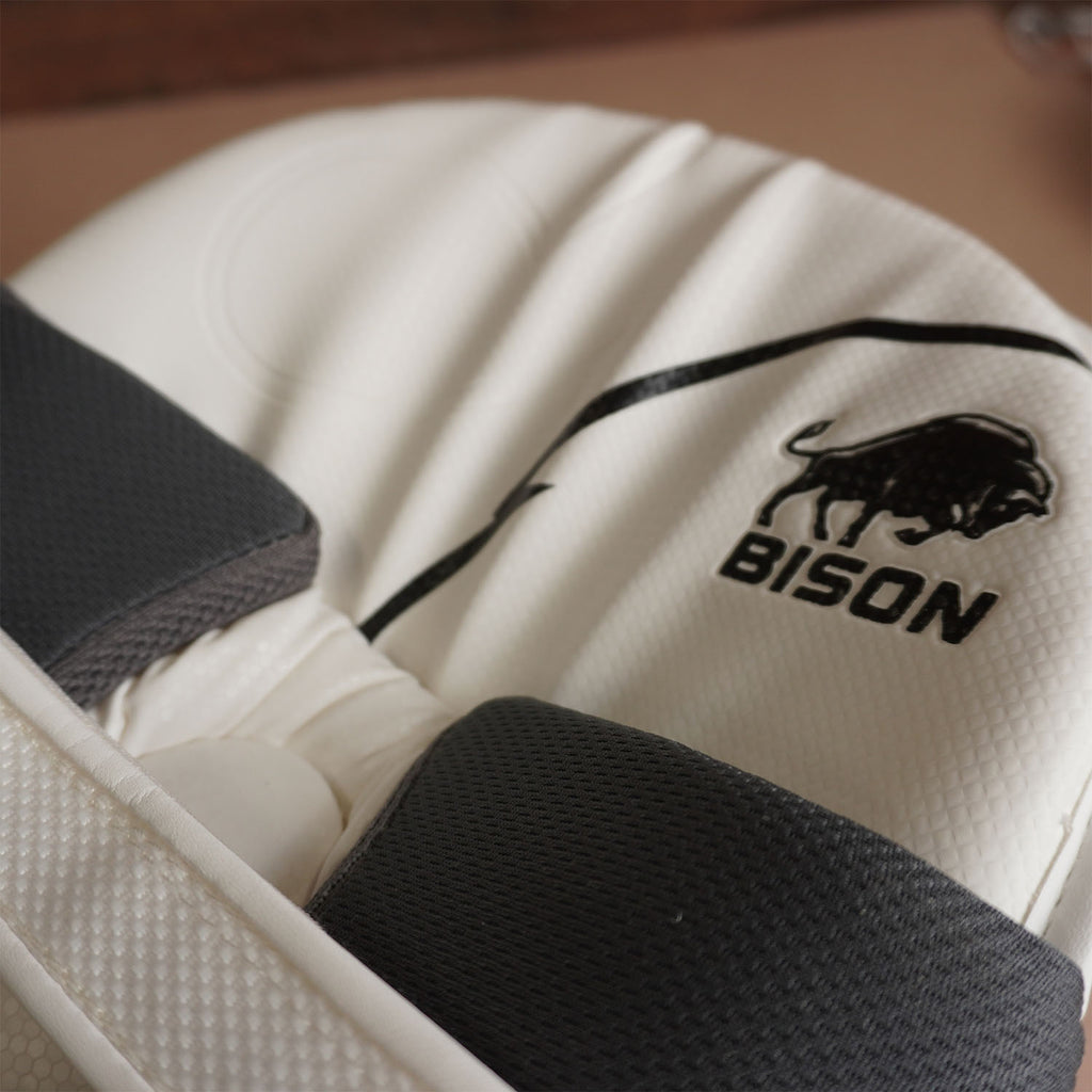 Close-up of Bison Cricket Pads showcasing premium foam and logo, designed for youth cricket protection and performance.
