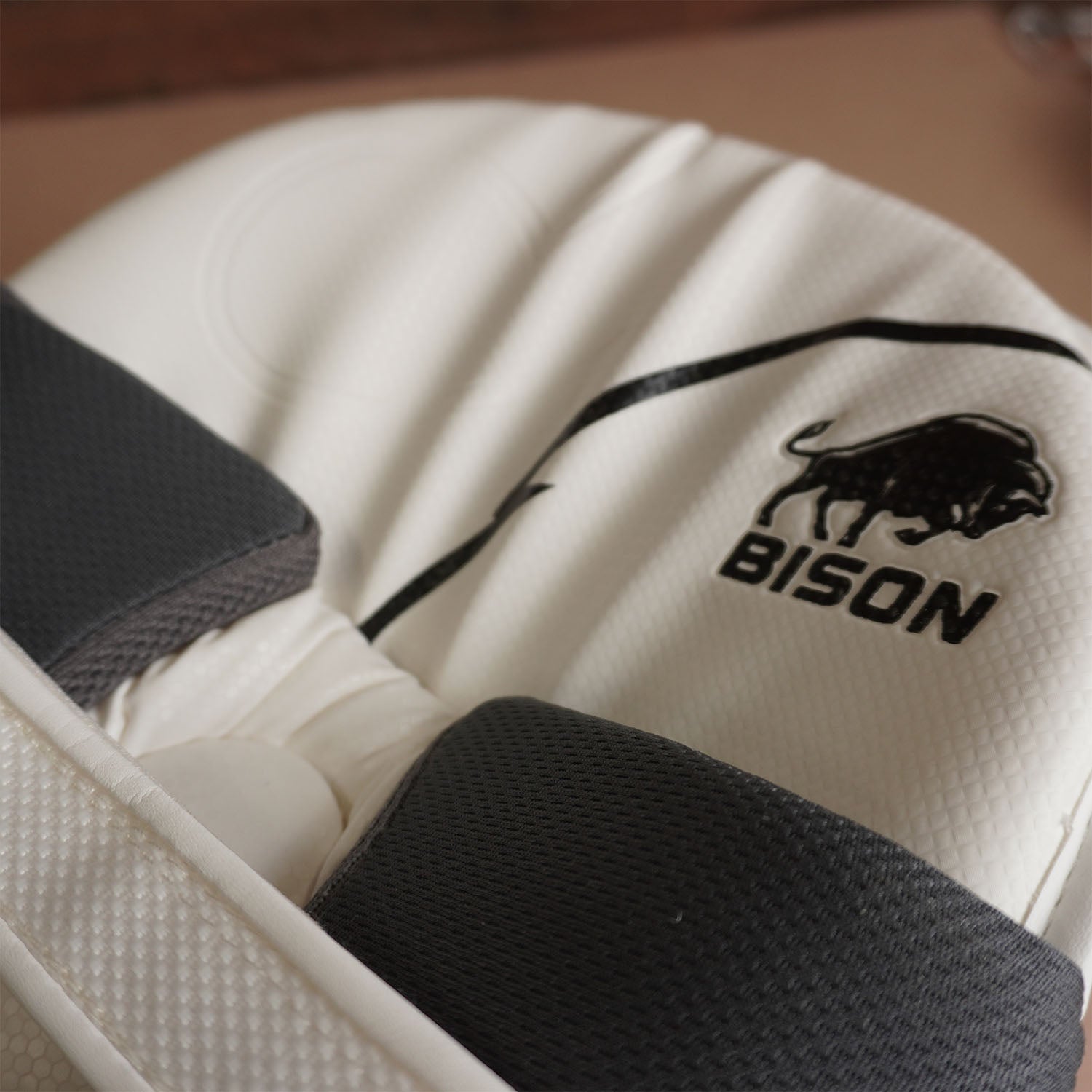 Close-up of Bison Cricket Pads showcasing premium foam and logo, designed for youth cricket protection and performance.