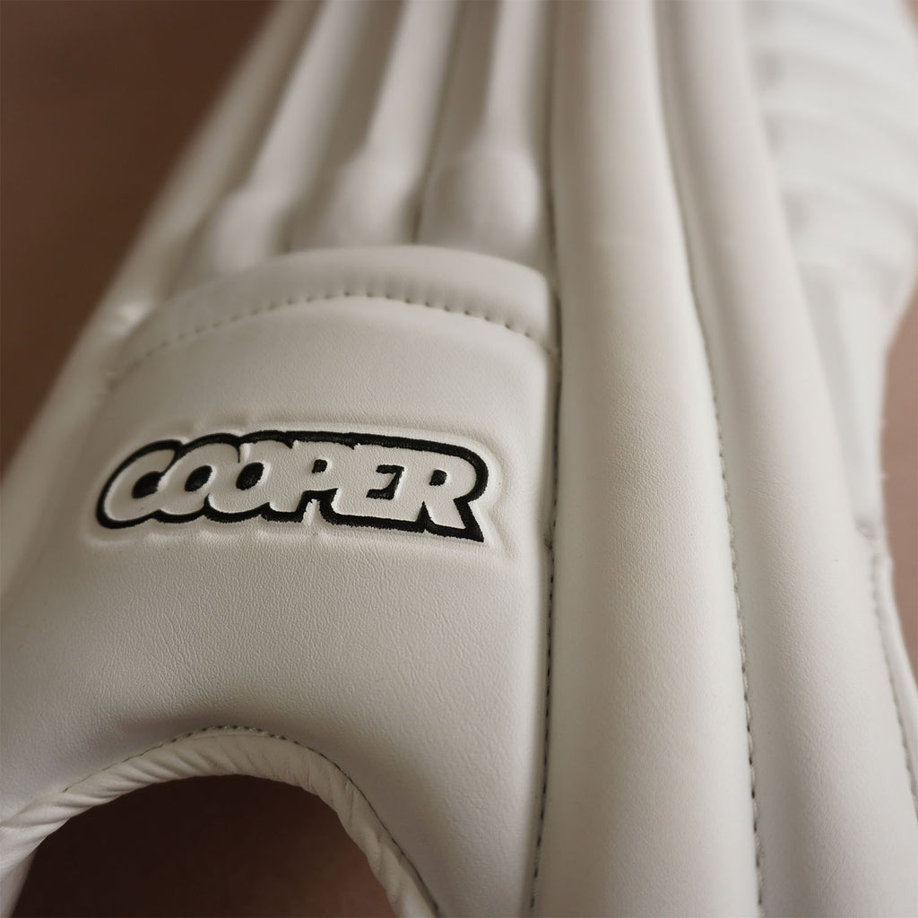 Close-up of a Cooper cricket pad showcasing its sleek design and premium white materials.