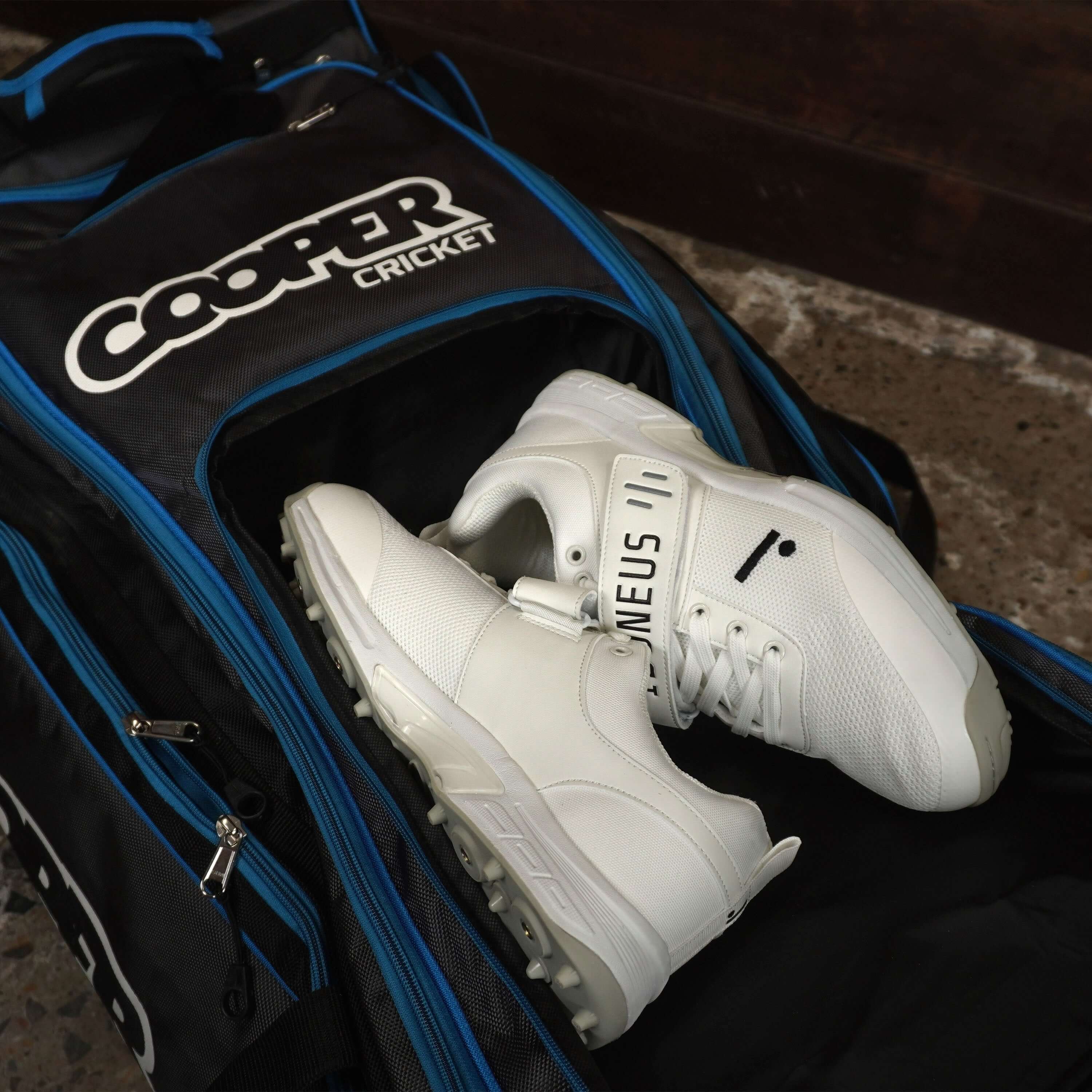 Cricket bag with white sports shoes in shoe compartment