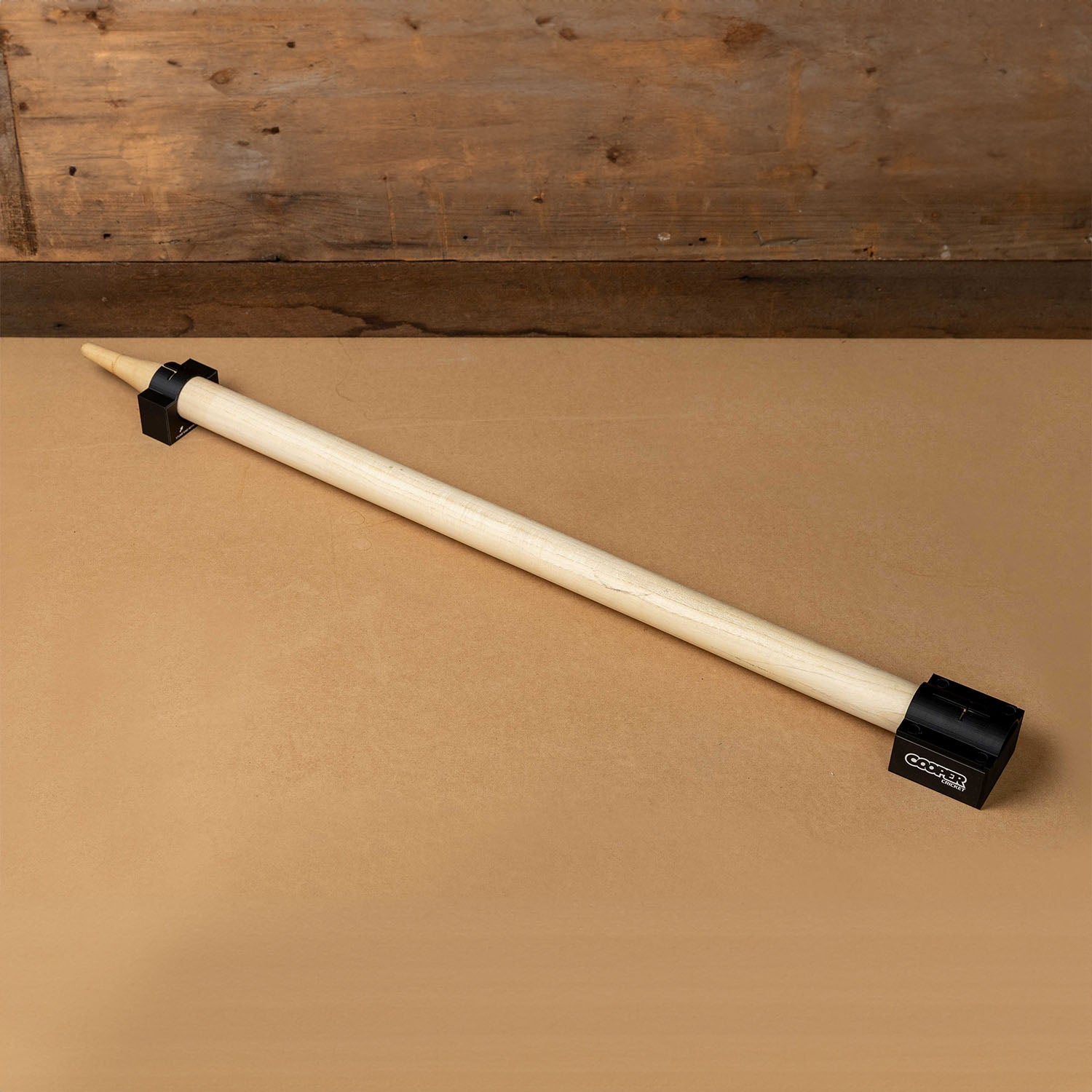 Cricket stump marker tool for precise sticker alignment on stumps, featuring an easy-to-use design on a wooden surface.