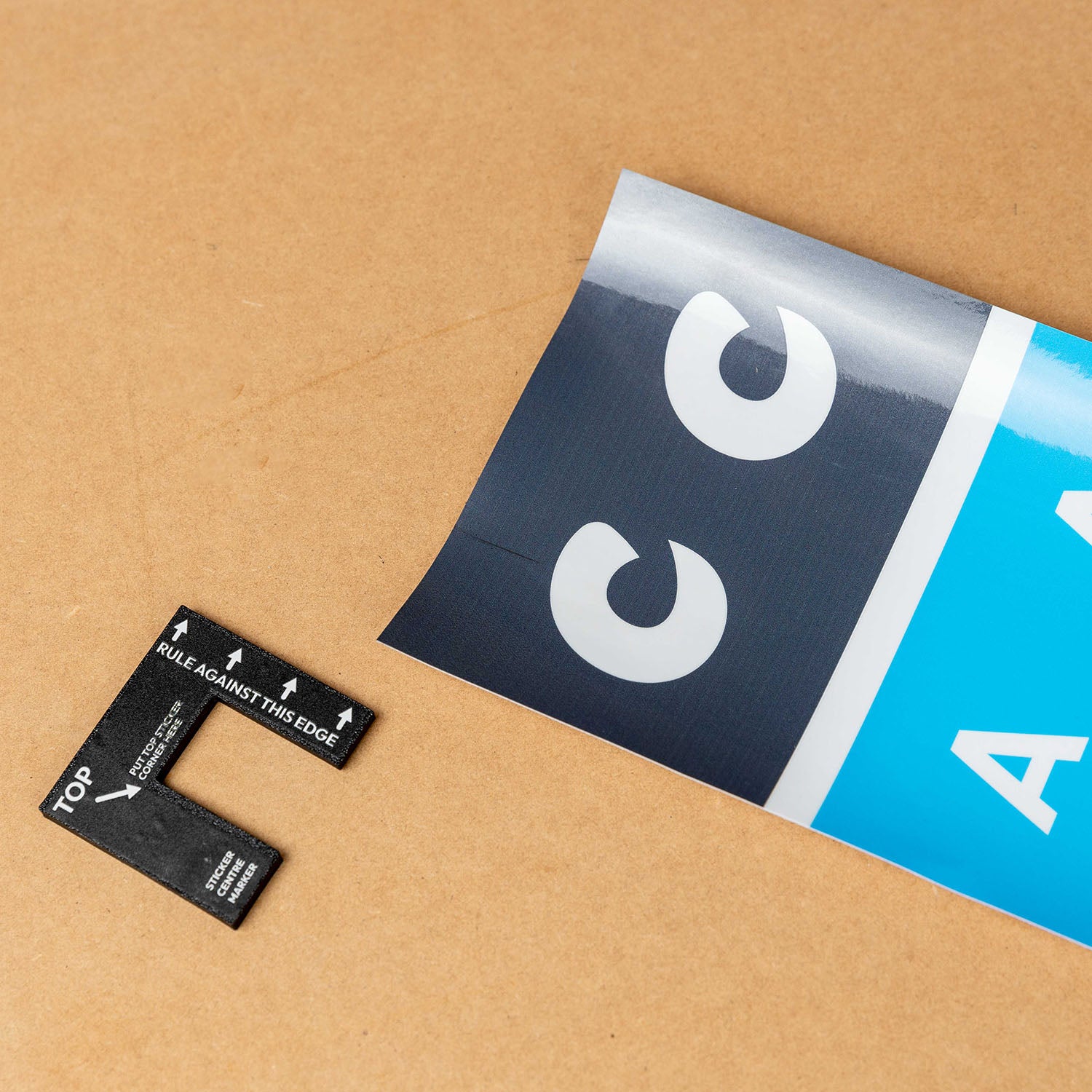 Cricket stump marker tool with custom sticker wrap on brown surface for precise alignment.