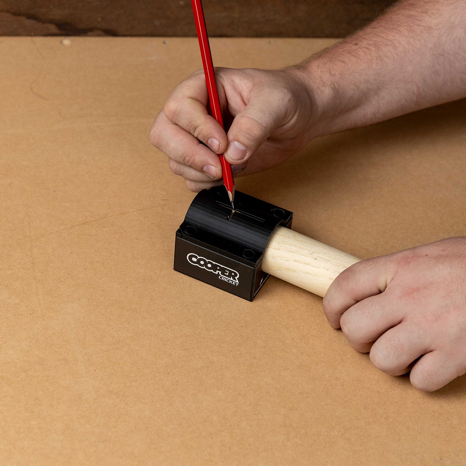 Person using Cricket Stump Marker tool to align custom stump wrap stickers for precise application.