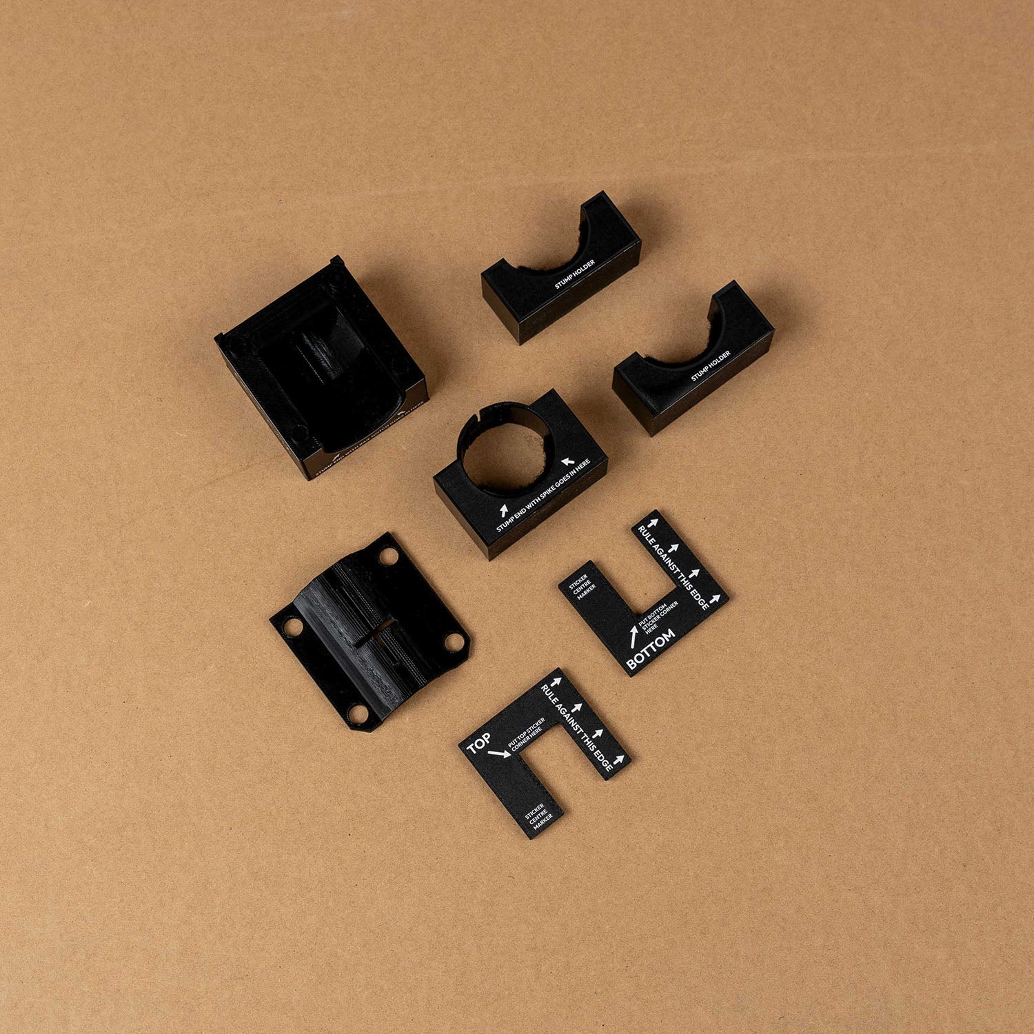 Cricket stump marker kit with alignment tools for custom sticker application against a brown background.