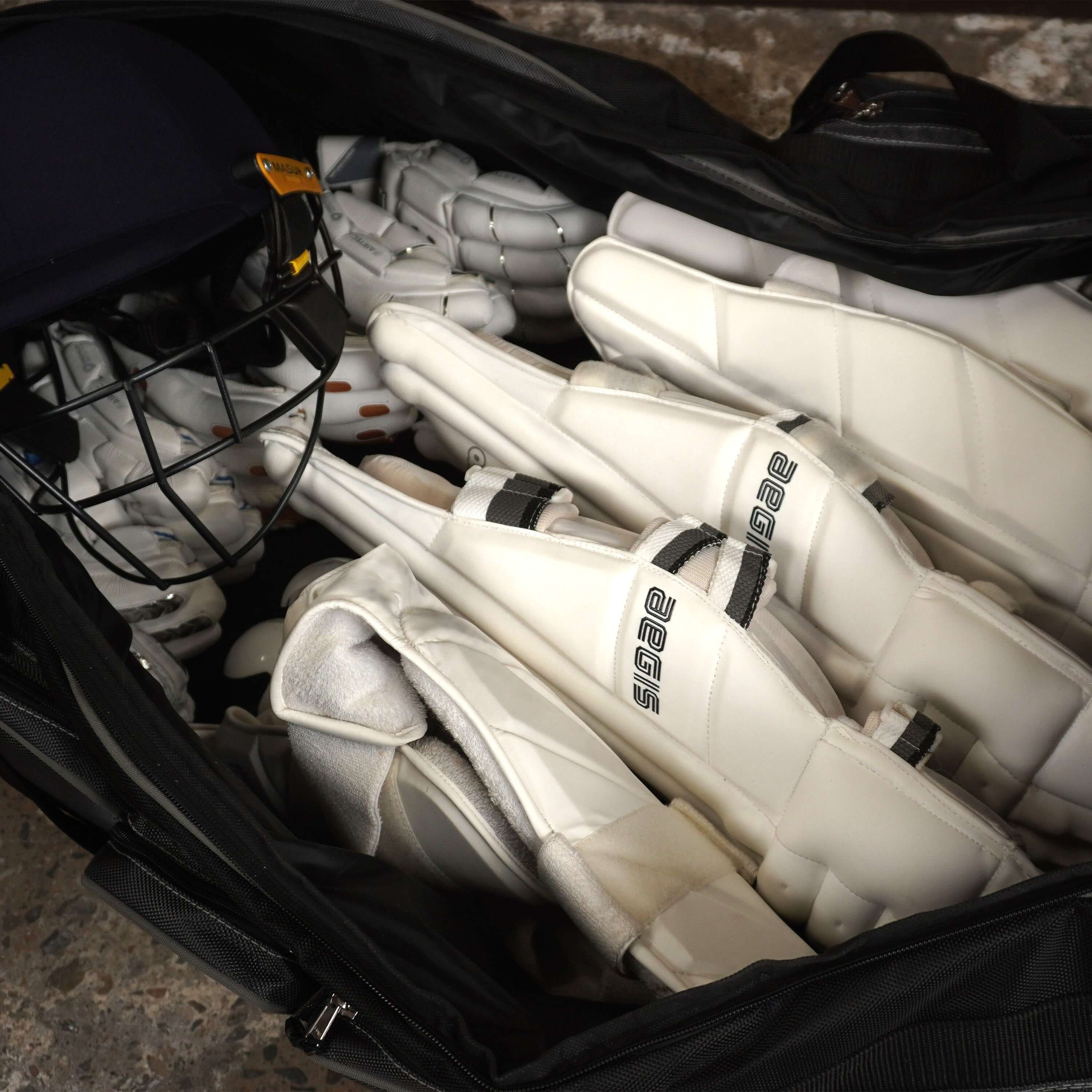 Spacious LX9 cricket bag filled with pads, helmet, and cricket gear, ideal for cricketers seeking a complete kit solution.