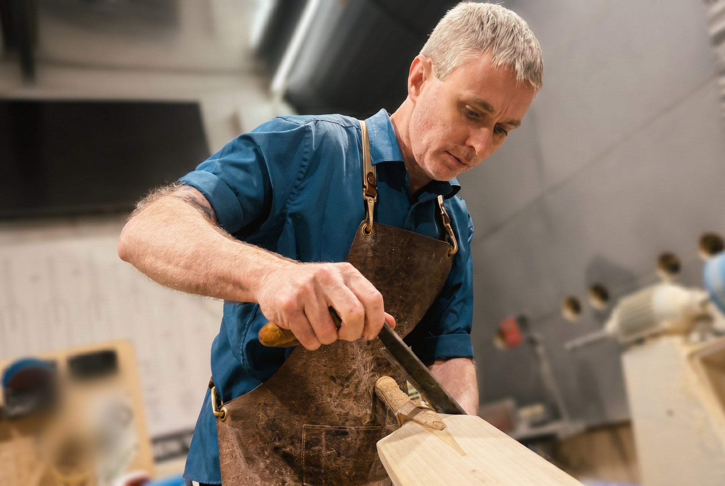 Cooper Cricket workshop, shaping a bat handle with a drawknife