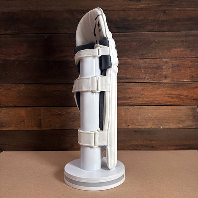 Bison Cricket Pads 2024-25 youth profile view showcasing premium foam and secure strap design on a display stand.