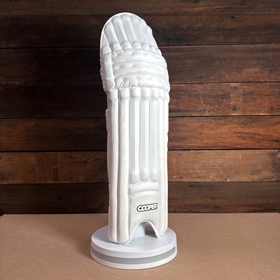 Cooper cricket pad displayed on a stand, showcasing sleek design and premium materials for enhanced performance.