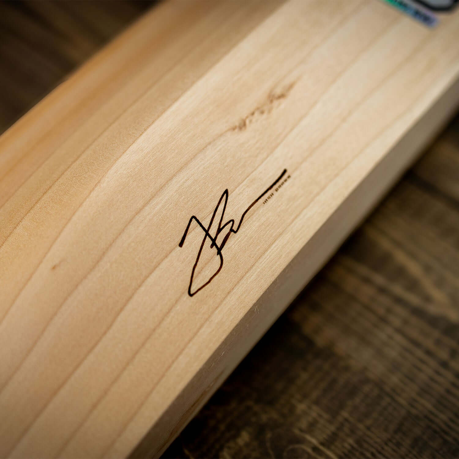 Close-up of JB140 Limited Edition cricket bat featuring Josh Brown's signature on the smooth wood surface.