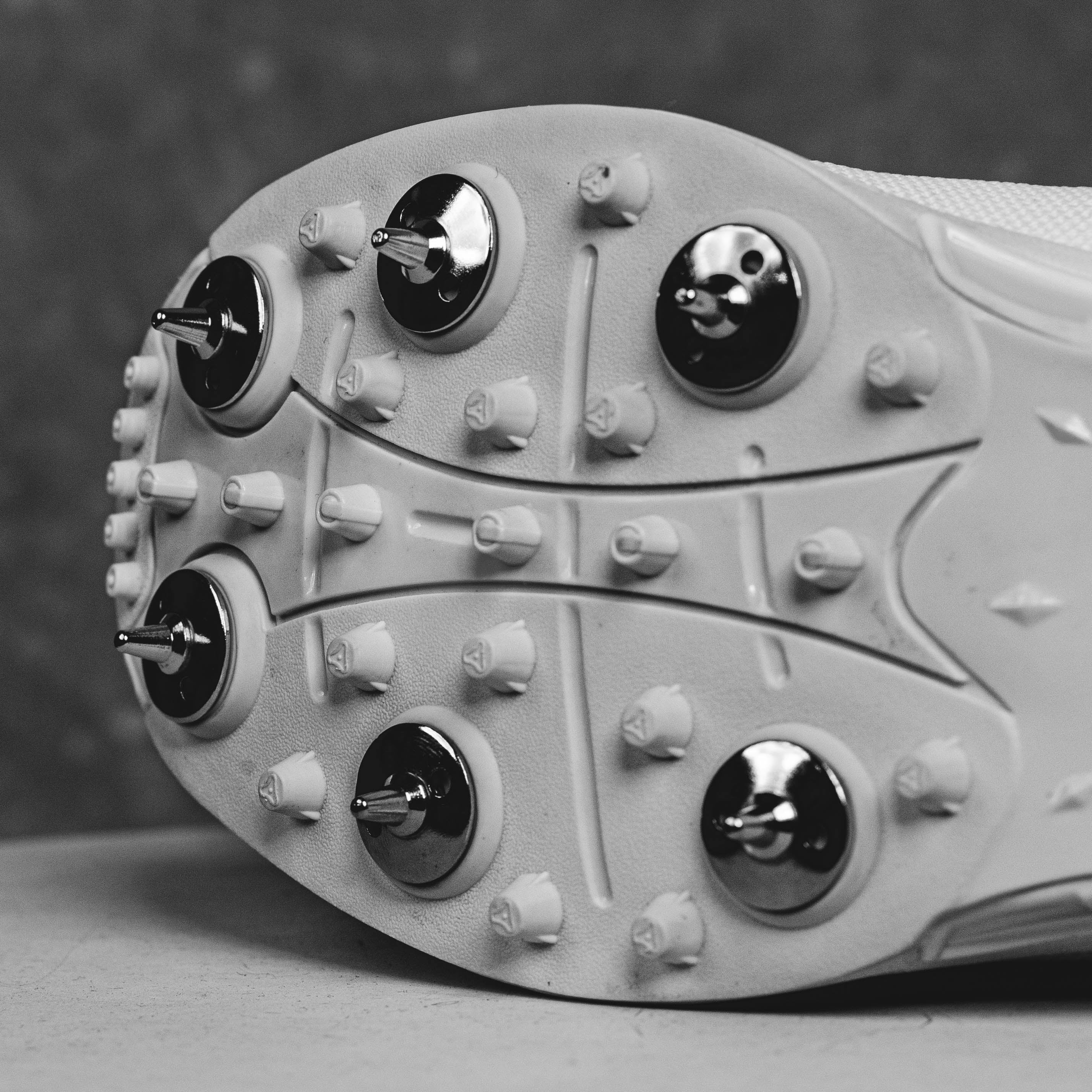 Close-up of IDONEUS ID1 Cricket Shoes steel spikes for superior grip and stability on various surfaces.