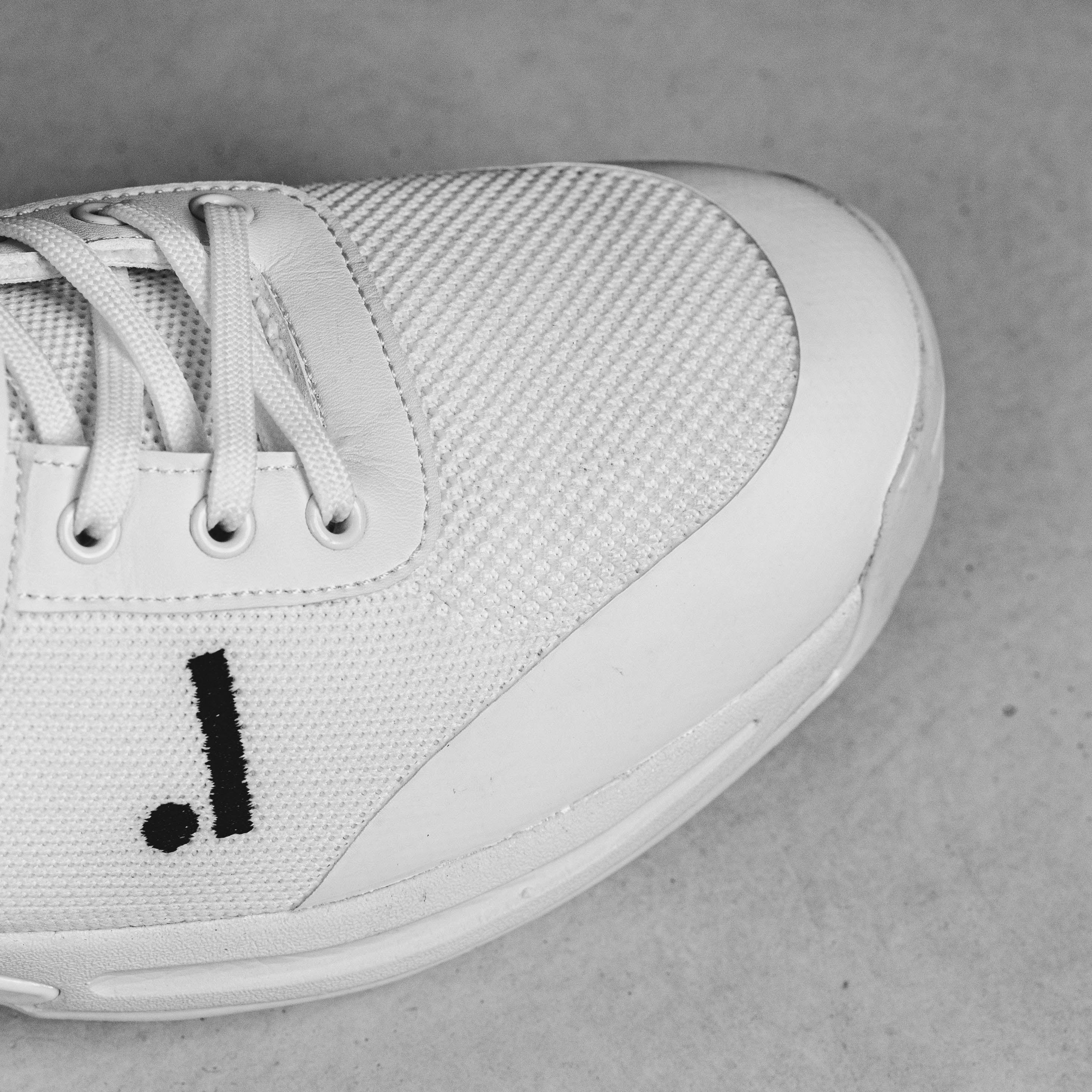 Close-up of Idoneus ID1 Cricket Shoe with white mesh design and unique logo, featuring enhanced durability and grip for cricket players.